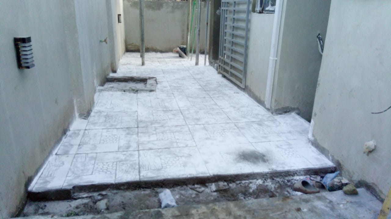 Stamped concrete walkway casting between building perimeter walls