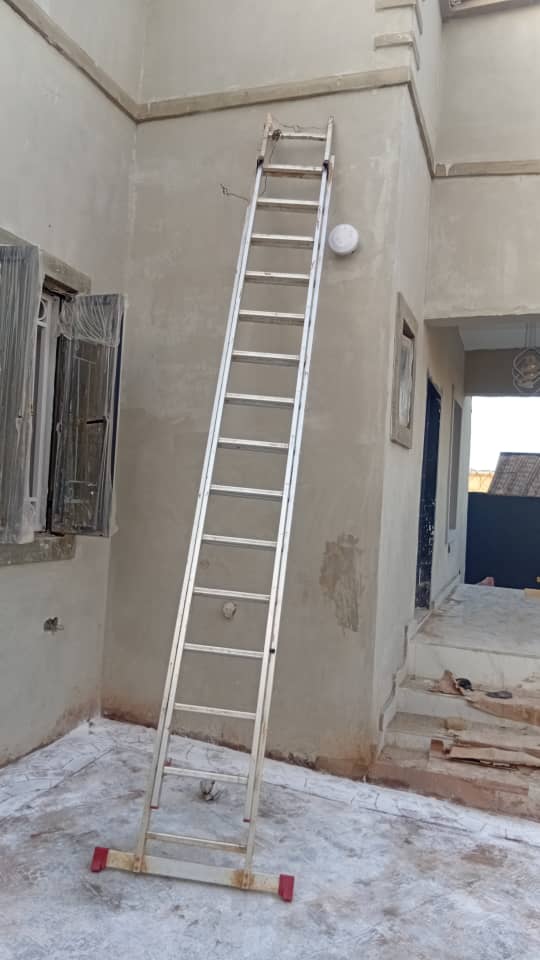 Extension ladder setup for high level exterior plastering and lighting